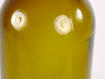 Close-up of shoulder mold seams on a four-piece mold bottle; click to enlarge.