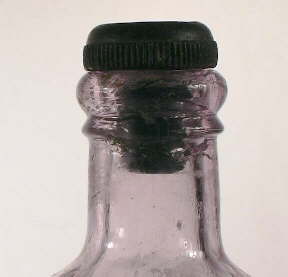 Image of an early 20th century ammonium bottle with an inside thread finish and hard rubber stopper; click to enlarge.