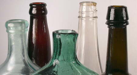 Different finish types on a group of five historic bottles.