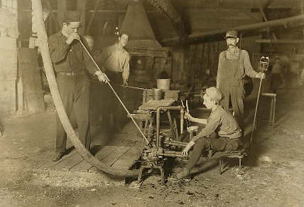 Gaffer and other helpers in a West Virginia glass factory in 1908; click to enlarge.
