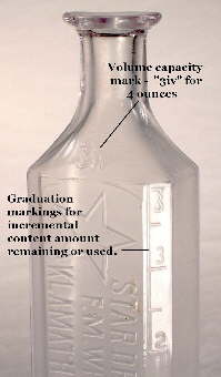 Graduation and capacity markings on an early 20th century druggist bottle; click to enlarge.