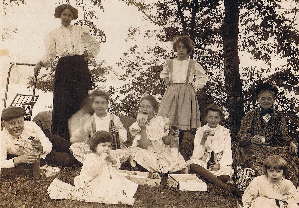 Early 20th century family re-using bottles on a picnic; click to enlarge.